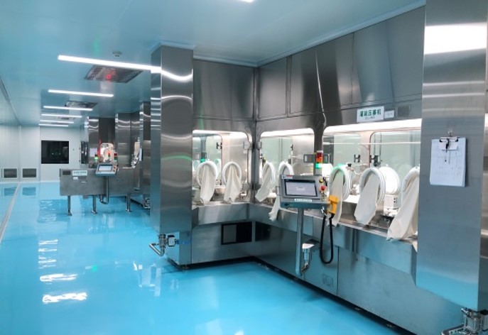 A view of Tofflon’s isolator system used in pharmaceutical manufacturing for contamination-free handling. The stainless steel structure features glove ports within a sealed environment, ensuring high safety and sterility standards in cleanroom and sterile production areas.